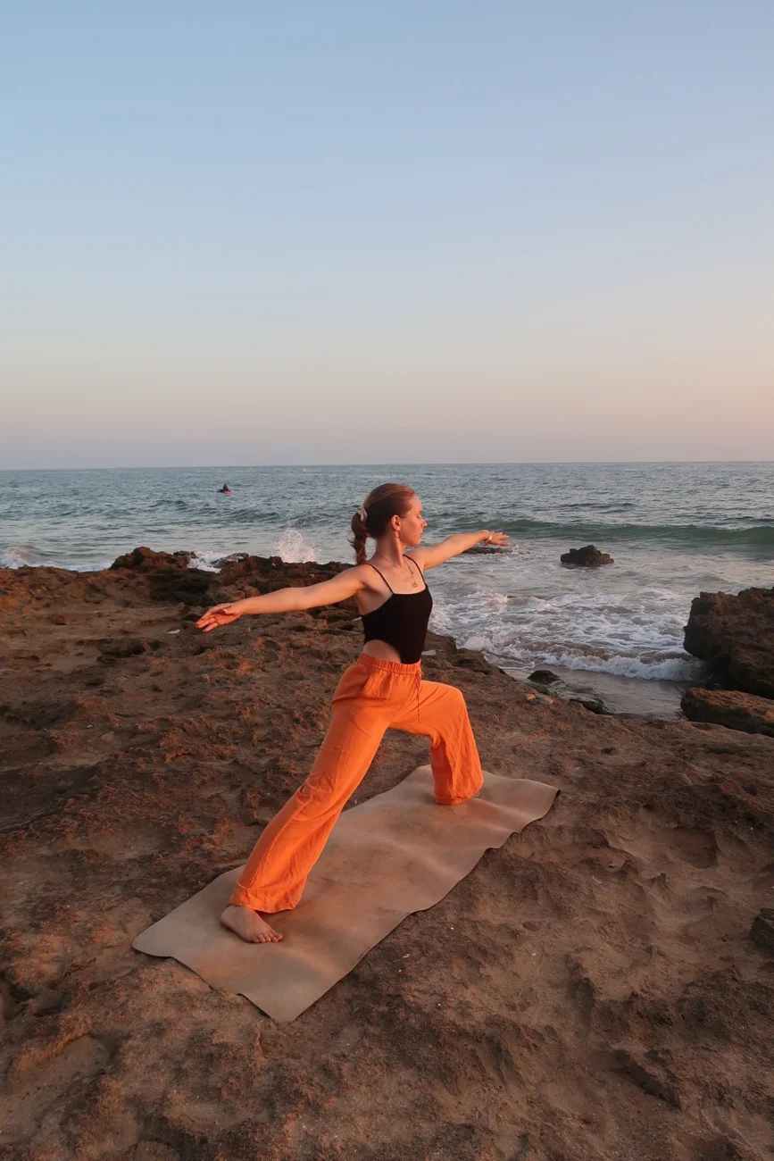 Larissa practising yoga by the ocean